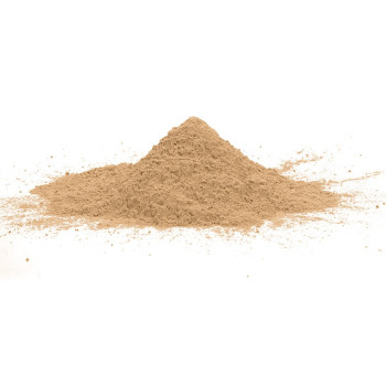 Une poudre beige forme un petit monticule légèrement dispersé sur un fond blanc uni.