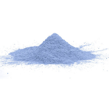 Un petit tas de poudre bleu pâle repose sur une surface blanche, suggérant un environnement de laboratoire calme et propre.