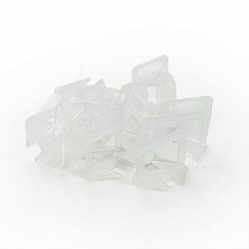 Transparent plastic bag clips are scattered haphazardly on a plain white background, forming a loosely connected pile.