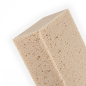 A beige, rectangular sponge with a porous texture sits against a plain white background.