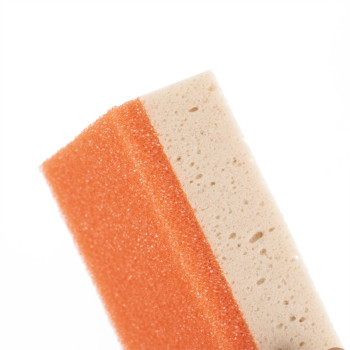 Zweischichtiger Schwamm. obere orange Seite und untere beige Seite. steht aufrecht vor einem schlichten, weißen Hintergrund und 