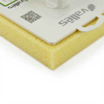 Una paleta blanca con mango de plástico está montada sobre una esponja amarilla, empaquetada con la marca. El texto incluye: `va