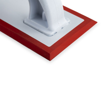 A white float with a sturdy handle sits atop a flat surface. It features a red rubber edge, ideal for smoothing or finishing app