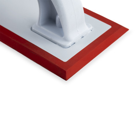 A white float with a sturdy handle sits atop a flat surface. It features a red rubber edge, ideal for smoothing or finishing app