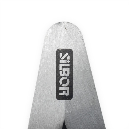 Metal caliper lies open. `SILBOR` text appears on one arm. Background is plain and white, emphasizing the tools polished surface