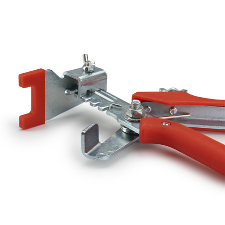 A specialized tool with red handles is gripping a metal piece, likely used for bending or holding. It rests on a plain white sur