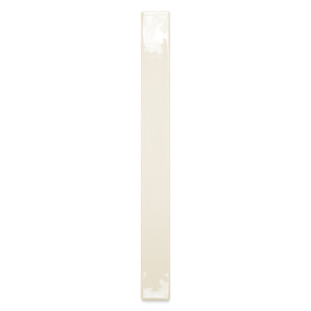 Un carreau de céramique étroit de couleur crème repose verticalement sur un fond blanc, réfléchissant subtilement la lumière sur