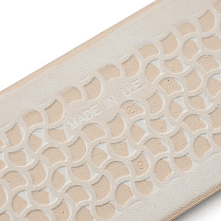 Een beige rubberen zool heeft een verhoogd, in elkaar grijpend geometrisch patroon met de tekst `MADE IN U.S.A.` reliëf in het m