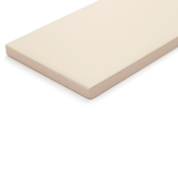 Un azulejo beige rectangular, liso, descansa sobre una superficie blanca, mostrando su superficie plana y limpia y sus bordes af