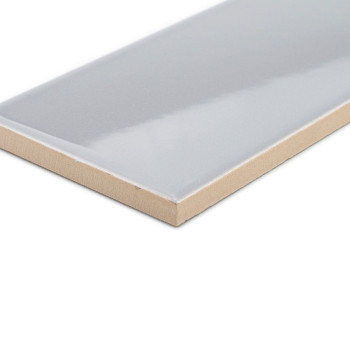 Um ladrilho cerâmico retangular, brilhante, cinza claro com uma borda bege fica isolado sobre um fundo branco em branco.