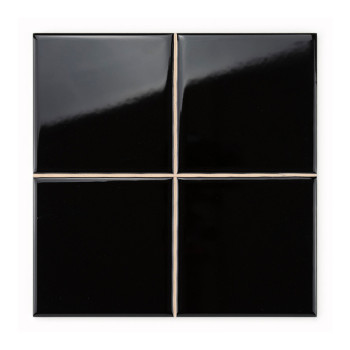 Cuatro azulejos de cerámica de color negro brillante forman un cuadrado, con limpias líneas de lechada que se cruzan, creando un