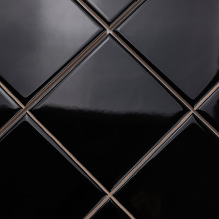 Ladrilhos pretos brilhantes em forma de diamante são dispostos em um padrão elegante e repetitivo, criando uma superfície elegan