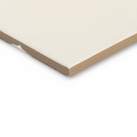 Un carreau de céramique rectangulaire repose à plat, montrant sa surface lisse de couleur crème et ses bords légèrement biseauté