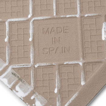 Un carreau texturé présente des motifs de grille en relief et le texte « MADE IN SPAIN » au centre, entouré de bords blancs.