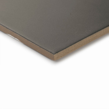 A smooth, dark-colored tile lies flat on a light surface, showcasing its sharp, clean edges and uniform thickness in a minimalis