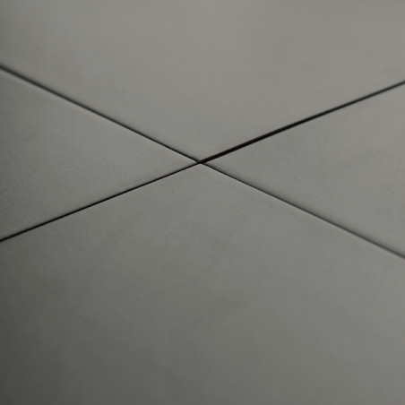Gray ceramic tiles intersect at right angles, forming a cross pattern, in a smooth, evenly lit environment.