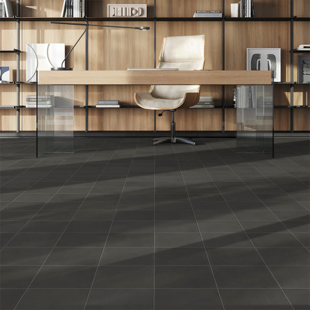 A sleek office chair sits behind a modern desk with glass legs. shelves filled with books and decor line the wooden backdrop.