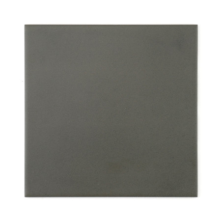 A square, matte dark gray tile lies flat, providing a minimalist and neutral surface, suitable for various interior or exterior 