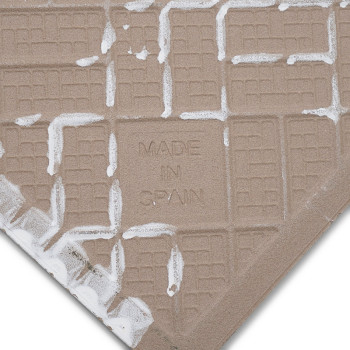 A square ceramic tile with a beige grid pattern features the text `MADE IN SPAIN` embossed on its surface, surrounded by white m