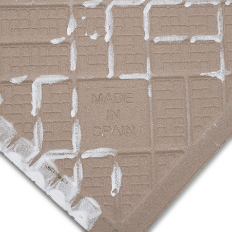 Een vierkante keramische tegel met een beige rasterpatroon is voorzien van de tekst `MADE IN SPAIN` in reliëf op het oppervlak, 