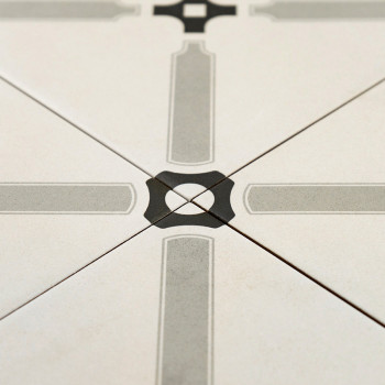 Een keramische tegel heeft een symmetrisch geometrisch patroon met elkaar kruisende grijze lijnen die een kruis vormen, gecentre