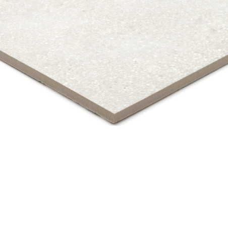 Un carreau de céramique rectangulaire gris clair moucheté repose sur une surface blanche, mettant en valeur son profil mince et 