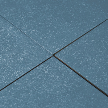 Les carreaux de céramique bleue sont alignés selon un motif en grille, mis en valeur par de subtiles textures mouchetées, avec u