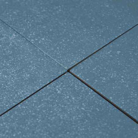 Les carreaux de céramique bleue sont alignés selon un motif en grille, mis en valeur par de subtiles textures mouchetées, avec u