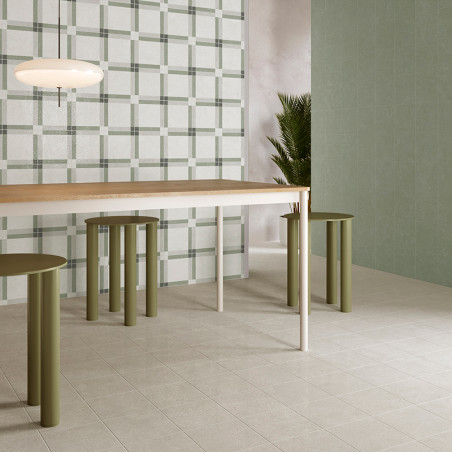 Uma mesa de jantar moderna com bancos cilíndricos verdes fica sobre um piso de azulejos claros, cercada por azulejos lisos e com