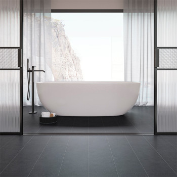 Une baignoire autoportante blanche est centrée dans une salle de bains minimaliste aux carreaux noirs, encadrée par de grandes f