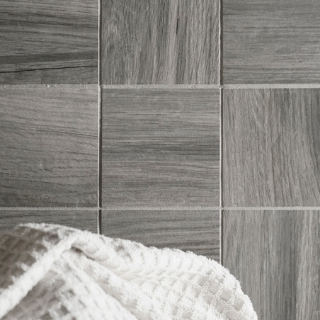Les carreaux gris avec une texture semblable à celle du bois sont disposés selon un motif en grille. une serviette gaufrée blanc