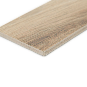 Un carreau de céramique rectangulaire à motif bois repose à plat, affichant une texture naturelle de grain brun clair. La zone e