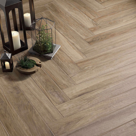 Des carreaux à motifs de bois posés en chevrons recouvrent le sol, entourés de lanternes et de petites plantes en pot pour la dé