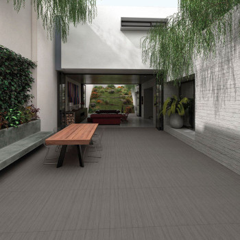 Une table rectangulaire en bois, entourée de chaises transparentes, se dresse dans un patio moderne avec de la verdure suspendue