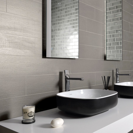 Un lavabo de salle de bains moderne est installé sur un comptoir élégant, accompagné d'un pain de savon et d'une bougie, contre 