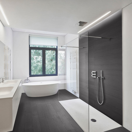 Un baño moderno cuenta con una elegante bañera independiente y una ducha montada en la pared en una habitación espaciosa con una