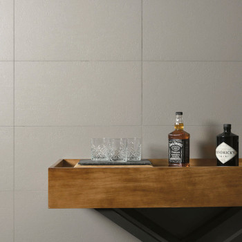 Twee flessen, één `Jack Daniels` en één `Hendricks Gin`, rusten op een houten plank met een kristallen glazen set. De achtergron