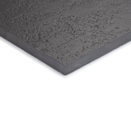 Un azulejo texturizado de color gris oscuro con una superficie ligeramente rugosa yace plano sobre un fondo blanco, mostrando su