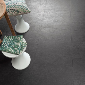 Los azulejos texturizadas de color gris oscuro se encuentran en un patrón de cuadrícula. Cerca se encuentran taburetes acolchado