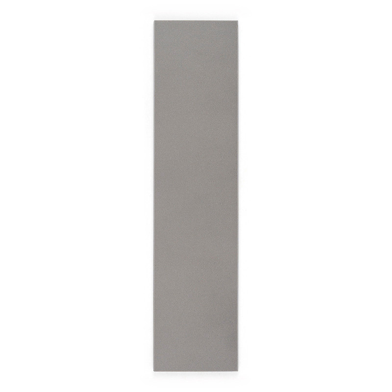 Un azulejo gris largo, rectangular, descansa verticalmente sobre un fondo blanco, enfatizando su superficie lisa y su diseño min