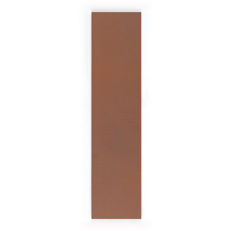 Un azulejo largo, rectangular, de color marrón rojizo yace plano sobre un fondo blanco liso, mostrando su textura de superficie 