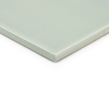 Un azulejo cerámico cuadrado, liso, verde y plano sobre un fondo blanco, muestra sus bordes limpios y su acabado brillante.