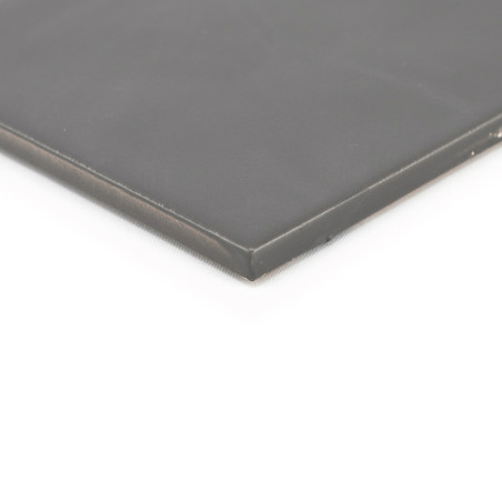 Um ladrilho liso cinza escuro fica plano, com bordas levemente chanfradas sugerindo durabilidade, contra um fundo branco liso.