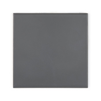 Un carreau carré gris foncé repose à plat sur un fond blanc, affichant une surface uniforme et lisse avec des bords légèrement a