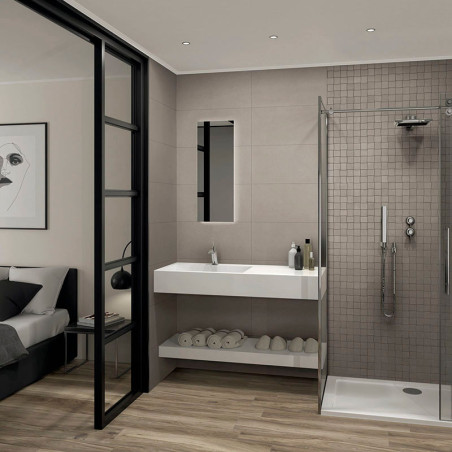 Une salle de bains moderne comprend une douche vitrée à droite, un élégant lavabo blanc avec des articles de toilette au centre 