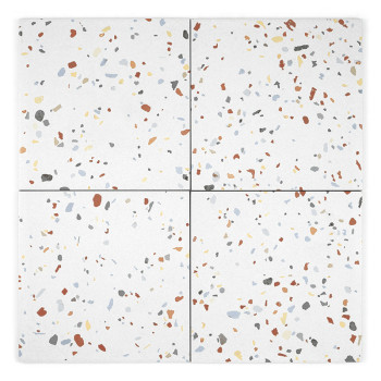 Un carreau de céramique blanche présente des taches colorées dispersées en rouge, bleu, gris, jaune et noir, créant un motif de 