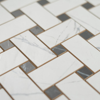 Des carreaux blancs rectangulaires avec de subtiles veines grises sont disposés selon un motif de brique décalé, entrecoupé de p