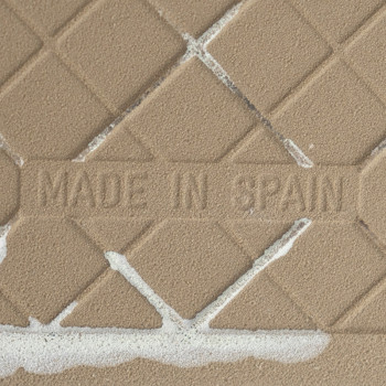 O ladrilho cerâmico castanho exibe um padrão de diamante sobreposto em uma grade texturizada, com `MADE IN SPAIN` gravado no cen