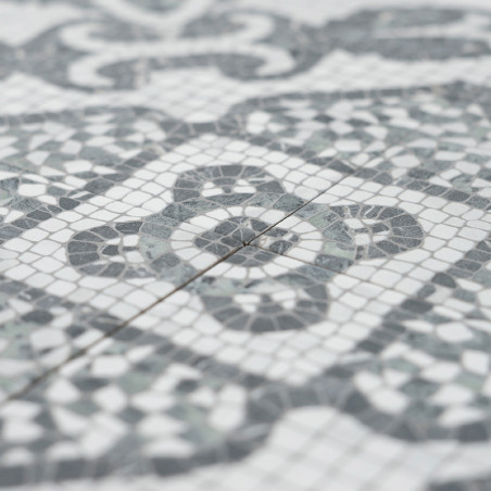 Graue und weiße Mosaikfliesen bilden komplizierte geometrische Muster und betonen Kreis- und Rautenformen. Die Fliesen liegen en