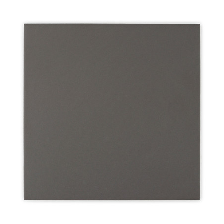 Un carreau carré sombre de couleur unie reposant sur un fond blanc uni.